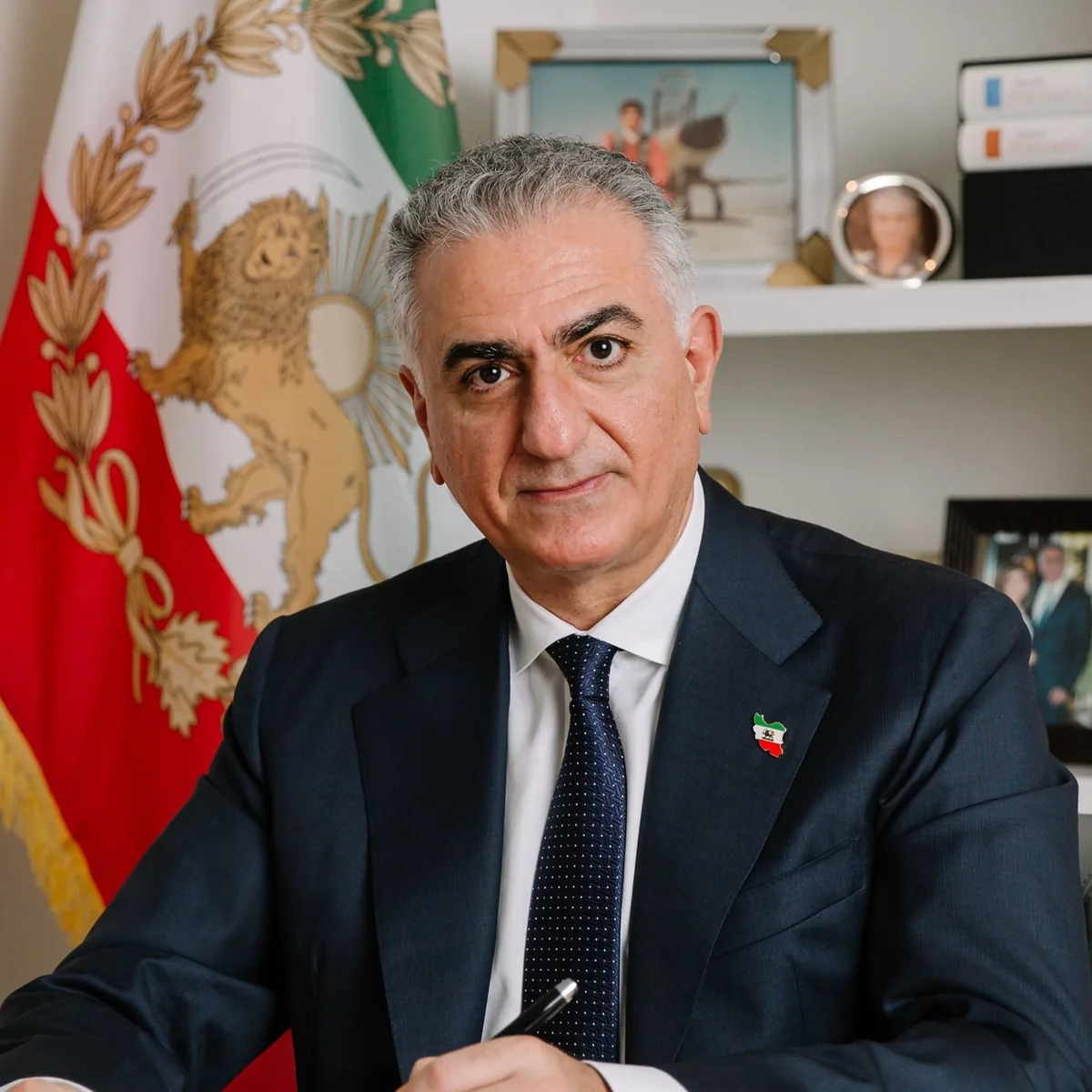 Crown Prince Reza Pahlavi in front of the Lion and Sun flag of Iran